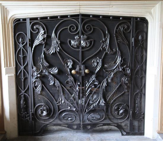 A black painted wrought iron and wire mesh chimneypiece spark guard, approx. W.4ft 6in.